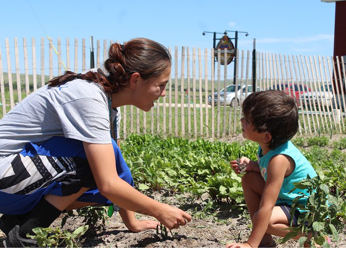 Woman and young boy work together in a community garden